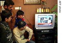 Iraqis in the northern city of Kirkuk watch the official television broadcast of Saddam Hussein's execution
