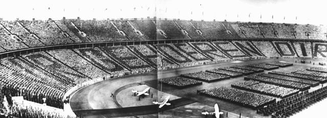 عند احتفال خلال الأعاب الأولمبية سنة 1936. يقول المتفرجون جملة متوجهة إلى هتلر:"نحن لك" (Wir gehoeren Dir). برلين, ألمانيا. أغسطس 1936.