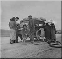 Migrants, family of Mexicans, on road with tire trouble.