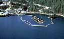 Aerial view of boom in water around salmon hatchery