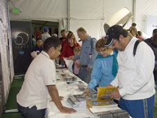 Dryden's Kim Lewis-Bias, who is representing the Innovative Partnerships Program office, hands out materials to visitors to the NASA exhibit.