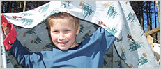 boy holding blanket over his head