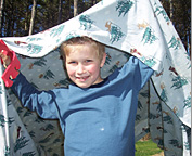 boy holding blanket over his head