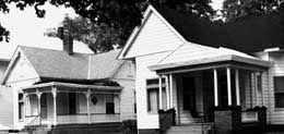 two houses showing wood siding and artificial siding