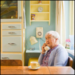 An elderly woman using the telephone