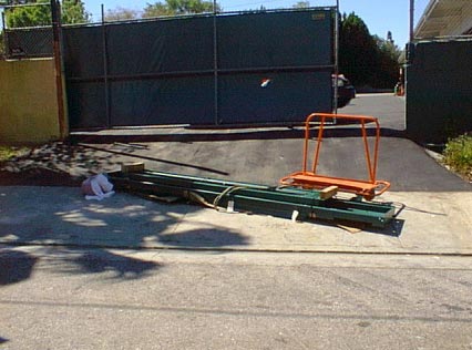 Exhibit #1  View of the incident scene showing the alignment rack, handcart, and the driveway incline.