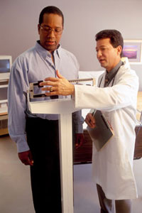 photo of a doctor weighing a man on a scale