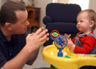 Image of a man practicing ASL with a toddler