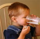 Image of a boy with a cochlear implant, drinking milk