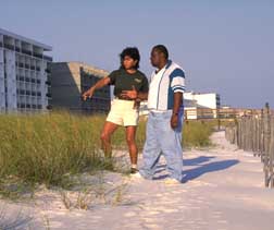 Magaly Rodriguez and Darryl Williams review the success of sand fencing and sea oats along Destin Beach.