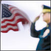 An American Flag being saluted by a soldier