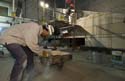 A stone mason trims a block of sandstone in the Great Hall