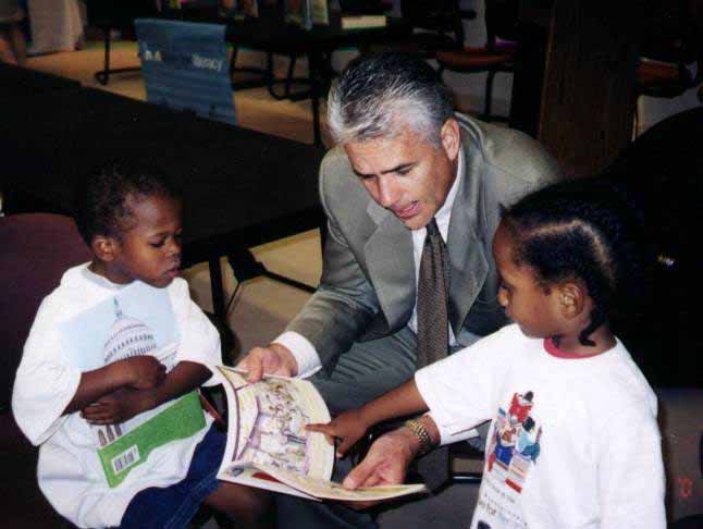 A picture of Senator Ensign reading to students.