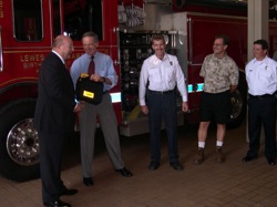 Senator Carper presents the Lewes Fire Company with a new defibrillator