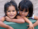 Two small girls smiling, one with a drinking cup