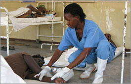 Nurse checks the intravenous (IV) fluid infusion for a cholera patient, Zimbabwe