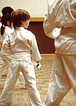 Children in white karate outfits taking a karate class. Tai Chi is available through Recreation Therapy.