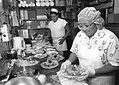 A woman working in a kitchen while her energy expenditure is measured.