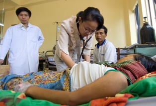 Doctors with a patient and her husband at a Cambodian AITRP hospital site. Photo: David Snyder
