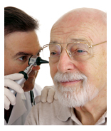 Photo of a male doctor examining an older, male patient’s ear with an otoscope.
