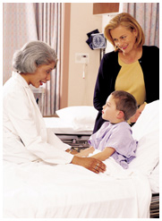 Picture of child in hospital bed meeting with a physician while mother looks on.