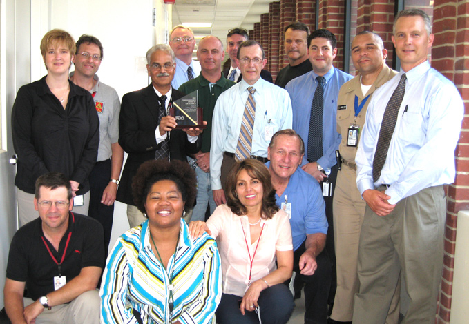 Among those honored for the new BSL-3 lab in Bldg. 29A are (seated, from l) David Shaw, ORF; Jacqulin Glass, ORS; Leila Nikkhoo, FDA; James O’Neil, ORF. In middle row are (from l) Sherry Bohn, ORS; Sam Denny, ORS; Gopi Boray, ORF; Martin McCourt, G. Bailey Co.; Howard Hochman, ORF; Ryan Bayha, ORF; Rafael Torres-Cruz, ORS; Kevin Wimsatt, G. Bailey Co. At rear are (from l) Kenneth Roman, ORF; Brian Temme, Jacobs Engineering Group; David Conrad, G. Bailey Co.