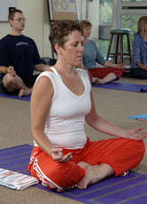 A woman Meditating during a yoga class.