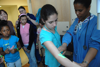 CC nurse Reggi Parker demonstrates how to find a vein under the skin for a blood draw.