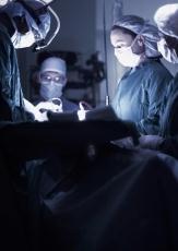 Photograph of male and female doctors performing surgery