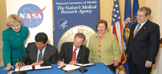 NIH director Dr. Elias Zerhouni and NASA administrator Dr. Michael D. Griffin sign an agreement making U.S. resources on the International Space Station available for NIH-funded research. Sen. Kay Bailey Hutchison (l), Sen. Barbara Mikulski and NIAMS director Dr. Stephen Katz witness the occasion.