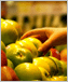 Photo of a hand picking up an apple in a supermarket.