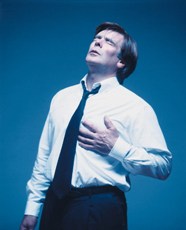 A photograph of a man clutching his chest