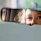 A drivers eyes viewed through a rear-view mirror