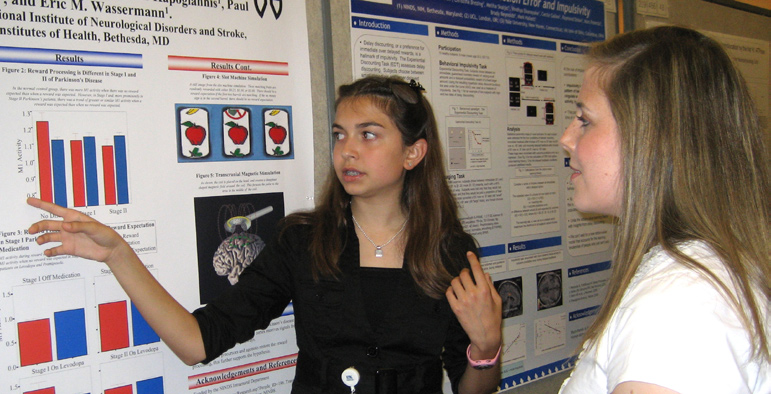 Kelsey Ladt (l) presents her poster at the 2008 Summer Poster Day, held Aug. 7 in the Natcher Bldg.