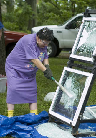 One of many BBQ attendees takes a shot at breaking a glass window brought by vendor Windows Plus.