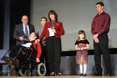 NICHD director Alexander (l) joins Jana Monaco (standing, c) and her children. The family benefited from studies conducted at an NICHD research center.