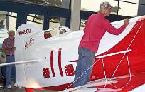 A worker does a final paint touchup before the Gee Bees debut in the San Diego Air & Space Museum.