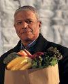 Man holding a grocery bag full of fruits and vegetables