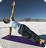 A man practicing yoga in the desert.