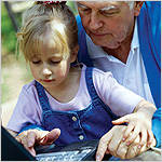 grandfather and granddaughter using laptop computer