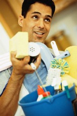 Photograph of a man carrying a bucket of household cleaning products