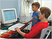 una mujer y un joven están usando una computador