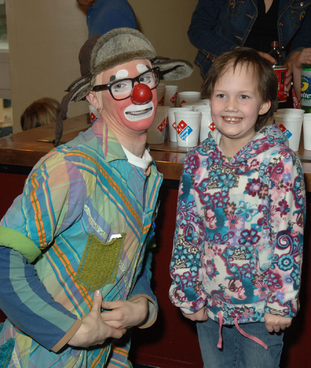 A youngster entertains Skoy as other circus performers