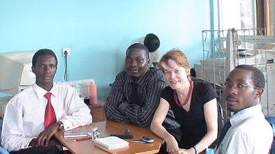 Royall meets with Makerere medical students and collaborators (from l) William Lubega, Nelson Igaba and Nixon Niyonzima.