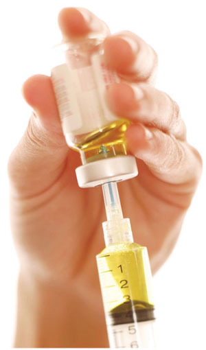 hand holding a needle and vial 