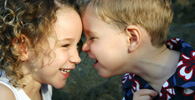 Children touching foreheads and smiling