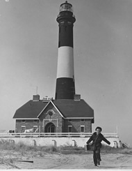 Photo:  young boy skipping away from lighthouse.