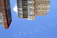 The word, "Uncle" in skytyping.  Tall buildings in the background.