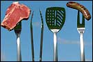 A steak and a bratwurst are impaled upon raised grilling forks