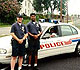 Police officers standing infront of the police vehicle